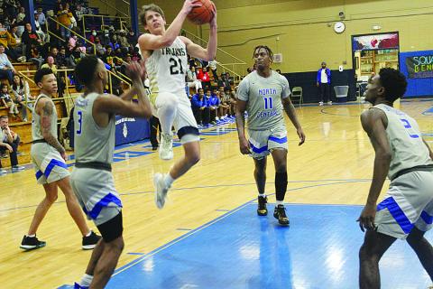 Austin Darbonne (21) goes for a basket against North Central. In the game against the Hurricanes, he recorded his 1,000th career point. (Gazette photo by Rhett Manuel)