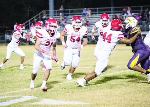 Pierre Berzas (54), Scott Berzas (60), and Da’Shawn Randall (44) pave the way for the Basile offense against an Elton defender.