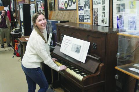 Marketing manager of Evangeline Parish Tourist Commission, Elizabeth West, tickles the ivories on the original piano from the Evangeline Club. (Gazette photo by Tony Marks)