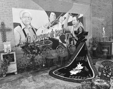 Abigail Fruge, the reigning La. Swine Festival Queen, poses in her full regalia at the Music of Basile mural in old downtown.