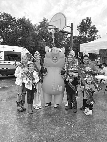 SWINE FESTIVAL ROYALTY ENJOYING LAST YEAR’S EVENT - (from left) Ava Manuel, Mallory Ortego, Bailey Stelly, Champion Hog Caller Jackie Ravey in the pig costume, Abigail Fruge, Carson Johnson, Vanessa Lastrapes, and Skyla McElfresh. 