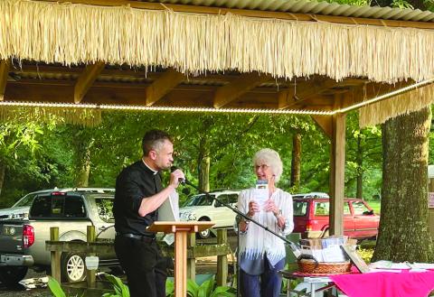Carrol LaFleur is pictured on the right as she talks about books on the life of Fr. Verbis LaFleur, who was declared a servant of God by the Diocese of Lafayette. Pictured on the left of Fr. Travis Abadie, pastor of St. Francis Regis Catholic Church of Arnaudville. (Photo courtesy of St. Bernard Catholic Church)