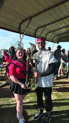 Tournoi champion Eric Guillory accepts his trophy from Louisiana Tournoi Queen Courtlyn Gremillion.