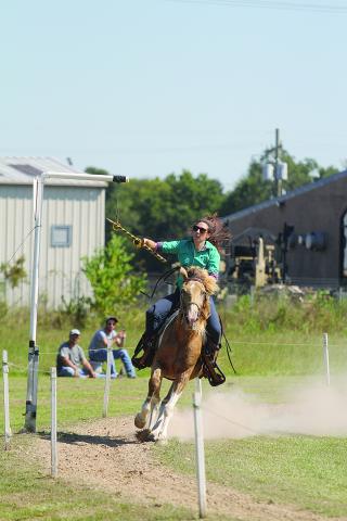 Marie Toustou, a native of the South of France, is pictured as she tries to collect one of the seven rings during the Tournoi qualifying held Sunday, September 26, at the Industrial Park in Ville Platte. (Gazette photo by Tony Marks)