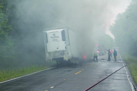 Pictured are firefighters as they battle to contain a truck fire on the Whiteville Road on Tuesday, May 3. What caused the refrigerated trailer to be engulfed in flames was not known as of press time.  (Gazette photo by Tony Marks)