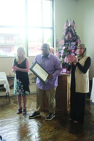 Mayor Ryan LeDay Williams (center) presents a proclamation to Boone’s daughters Carmen Bellard-Foutch (left) and Rachel Escamilla (right).
