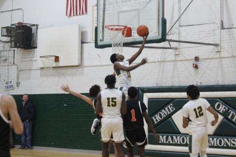 Tyrion Broussard (10) elevates himself over a pair of Pine Prairie defenders. Gazette photo by Rhett Manuel