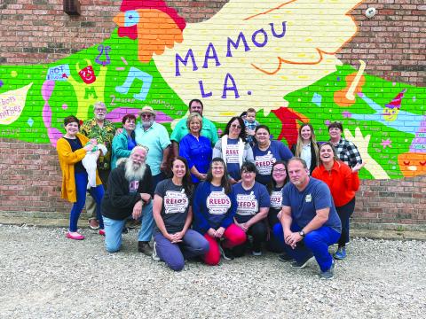 Local artist unveils Mamou mural located on Reed’s Pharmacy building
