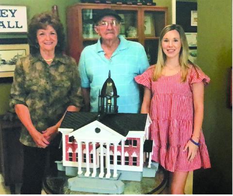 Helen M. Thibodeaux, Gene McMillan, and Marketing Manager for Evangeline Parish Tourist Commission Elizabeth West are pictured above left to right.  They are pictured with a replica of the original Evangeline Parish Courthouse constructed by McMillan and painted by his sister, Thibodeaux. (Photo by Bobby Dardeau)