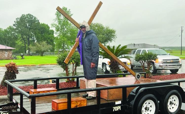 Reverend Matthew Alfred Jr., moderator of the Eastern Seventh District Association, carries the cross as the motorcade departs from Mt. Pilgrim Baptist Church, on Pine Point Road. The event, on Good Friday, culminated with meditations on the Last Seven Sayings. (Gazette photo by Tony Marks)