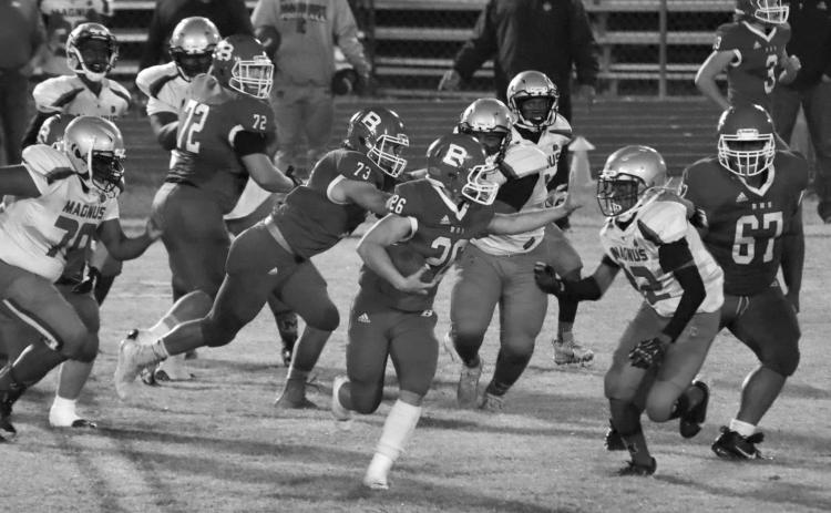 Ashton Deville (26) runs right at a Magnolia defender while Christian Bergeron (73) and Anphrony Guillory (67) play their respective roles in Basile’s galloping round one playoff win last week. (Photo by Nikki Johnson)