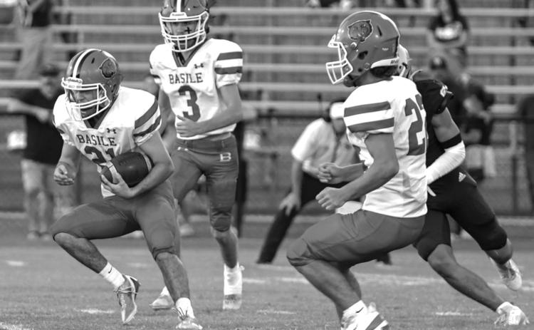 Basile High’s Kye Smith (21) puts the ball into play against Sacred Heart with teammates Sayg Smith (3) and Logan Bergeron (22) by his side. (Photo by Tonya Ortego)