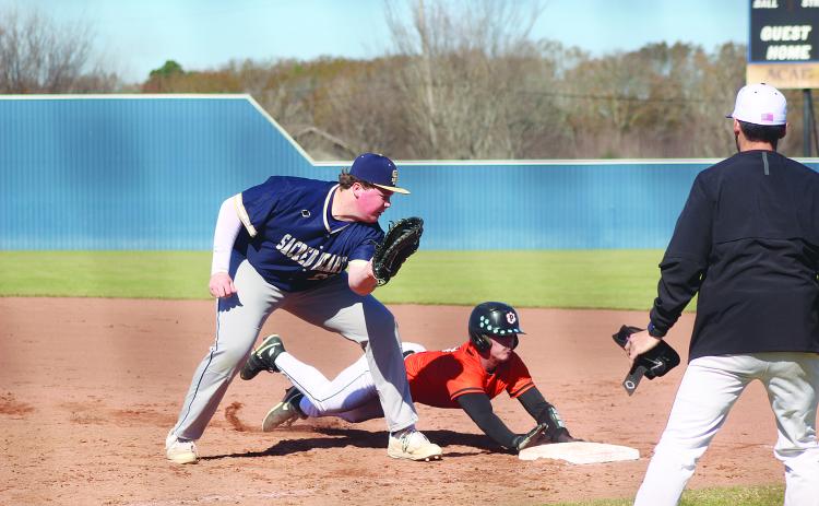 Weston Byrd (10) slides underneath the tag from Sacred Heart first baseman Liam Vidrine (28) as the Pine Prairie Panthers took on the Trojans in the Perry Pitre Baseball Jamboree. (Gazette photo by Tony Marks)