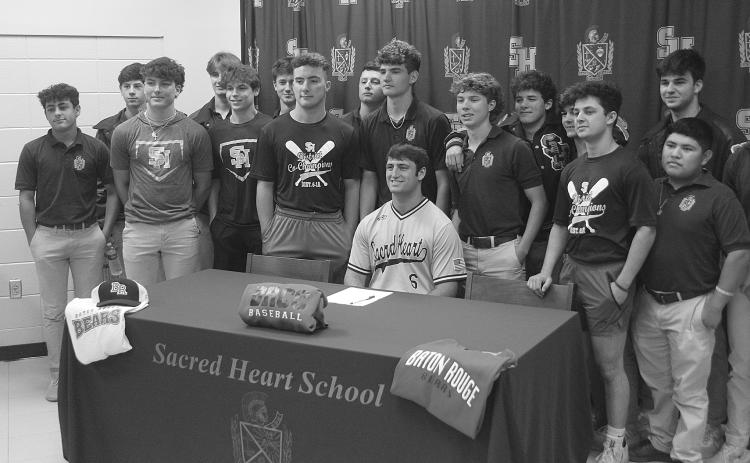 While flanked by members of the Sacred Heart baseball team, Briggs Ardoin (seated) is pictured after signing to continue his playing career at Baton Rouge Community College. Among those also pictured are Ellis Fusilier, Parker Feucht, Hayden Droddy, Sam Veillon, Nick Fontenot, Everett Johnson, John Michael Duplechin, Jackson Bruney, Boyce Schexnider, Brad Fusilier, Wade Pitre, and Sam Richardson.