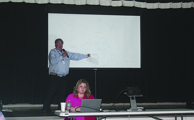 Standing is Michael Simms, Ph. D. (geology, hydrogeology) as he points out the location of the three currently proposed sites for carbon dioxide sequestration in Allen Parish. Seated is Emily Welch, who served as the moderator during the public hearing held Monday, April 28. (LSN photo by Tony Marks)