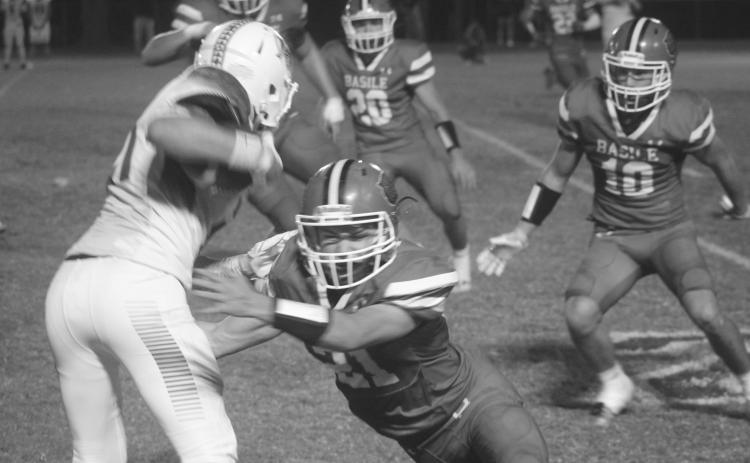 Basile’s Kye Smith (21) attempts to make a stop against a Hamilton Christian playmaker in the Bearcats’ 39-13 home loss against the Warriors. (Gazette photo by Tony Marks)