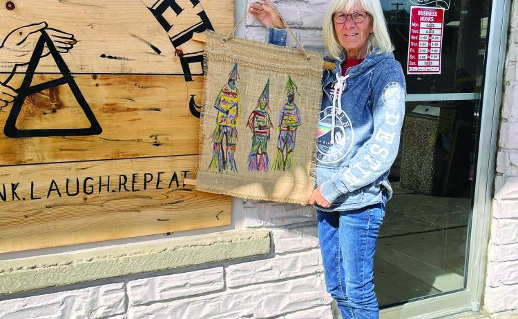 Kay Granger is shown with one of her many displays that hang inside the Greas E. Pete’s in Mamou. (Gazette photo by Heather Bogard)