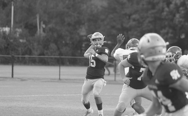 Wade Pitre (15) delivers a pass for Sacred Heart against Bunkie in a pre-season scrimmage. In Week 3, against Basile, he delivered pass to Hayden Droddy for 21 yards and a touchdown as time expired to put his Trojans at 3-0 on the season. (Gazette photo by Tony Marks)