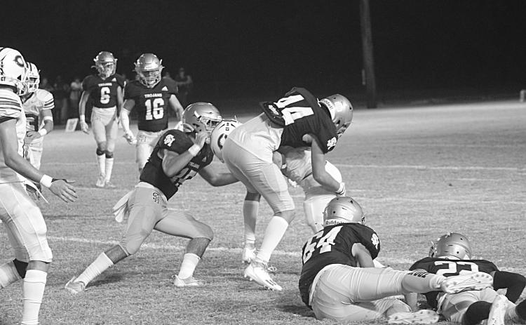 Defenders of Troy, led by Wade Pitre (15), combine for a stop against the Hornets of Catholic-Pointe Coupee in the teams’ district opener Thursday night. (Gazette photo by Rhett Manuel)