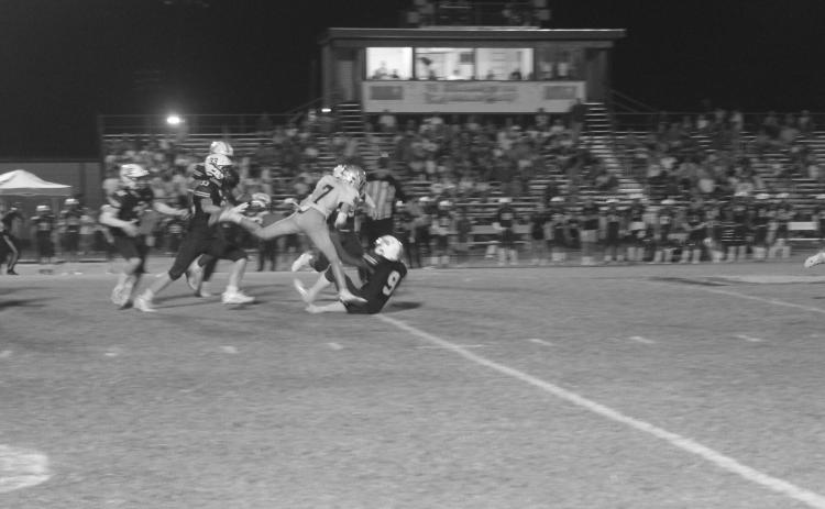 A banged up Hayden Droddy (7) fights for yardage after getting tripped up by several Eagles from Holy Savior Menard. Droddy and the rest of his Sacred Heart Trojans moved to 4-0 after a 20-0 win Friday night. (Gazette photo by Tony Marks)