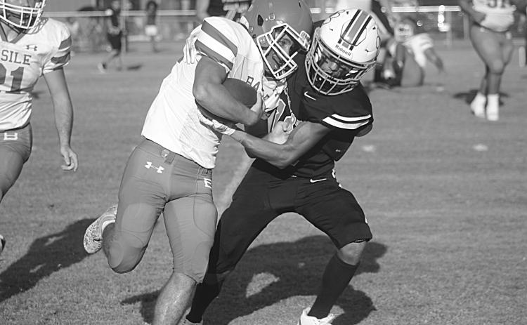 Pine Prairie’s Jayland Duplechin (13) looks to bring down Basile’s Logan Bergeron (22) in the first game of the jamboree. (Gazette photo by Tony Marks)