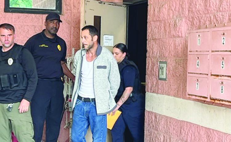 James “Jimbo” Fontenot is pictured in the center as he is transported from the Ville Platte Police Department to the Evangeline Parish Jail on Wednesday afternoon. He is escorted by officers Brandin Fontenot (left) and Darrian Guillory (right). Holding the door is Police Chief Al Perry Thomas (Gazette photo by Tony Marks)