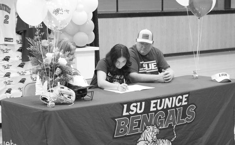 Ava Kordish (center) signs the paperwork to officially join the LSUE softball team during a ceremony held inside the Pine Prairie gym on Tuesday, November 14. Also pictured are her mother, Shelly Kordish; and her father, Skylar Kordish. (Gazette photo by Tony Marks)