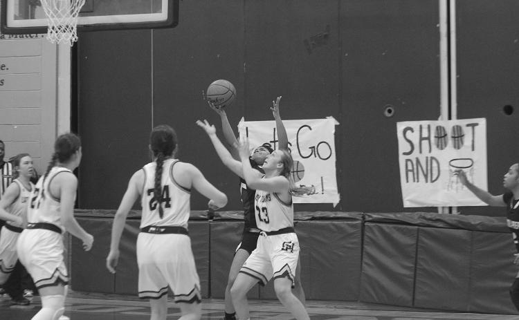 Members of the Lady Trojan basketball team watch as Jodie Landry (23) tries to steal the basketball from a Lincoln Prep player. The team now hosts St. John, of Plaquemines, with a trip to the state tournament on the line. (Gazette photo by Rhett Manuel)