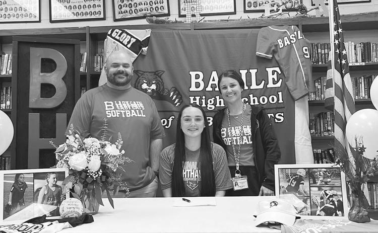McKinley Guillory (seated) is flanked by Bearcat softball coaches Collins Barnes and Kristen Bacon during the recent letter of intent signing for the Basile High School softball senior.