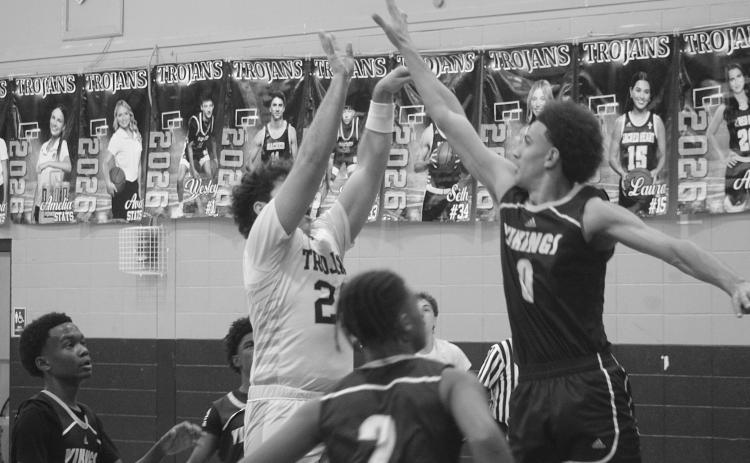 Lane Joubert (24) finishes his attempt at a basket in Sacred Heart’s district opening loss to Opelousas Catholic. Joubert led the Trojans with 12 points. (Gazette photo by Tony Marks)