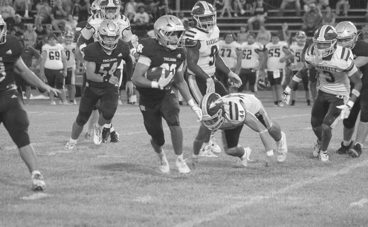 Trojan runner Gavin Patin (22) finds a running lane against the Oakdale Warriors in Sacred Heart’s season-opening 34-6 win at home Thursday night. (Gazette photo by Tony Marks)