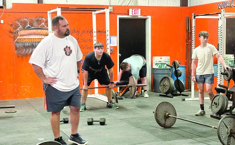 Pine Prairie head football coach Lance Myers (left) watches as members of the team lift weights during summer workouts. (Gazette photo by Tony Marks)