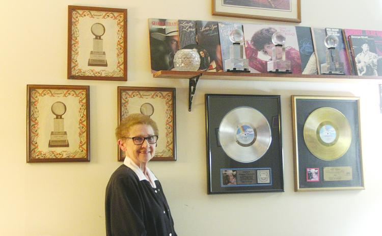 Retired Evangeline Parish School Board Member Peggy Forman stands alongside her platinum and gold records and other items from her career in Country music. (Gazette photo by Tony Marks)