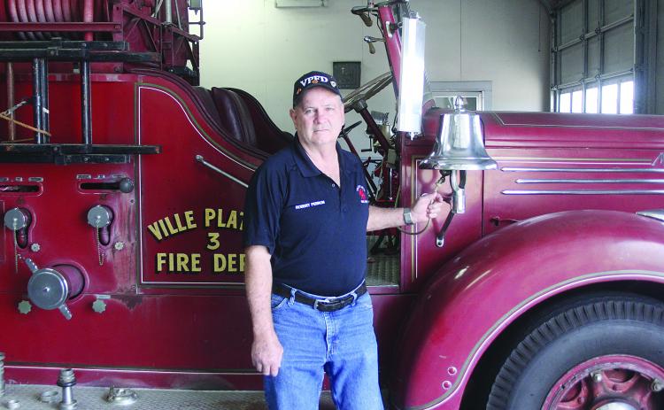 Robert Perron, a 50-year veteran of the Ville Platte Fire Department, is pictured as he rings he bell on fire truck No. 3. (Gazette photo by Tony Marks)