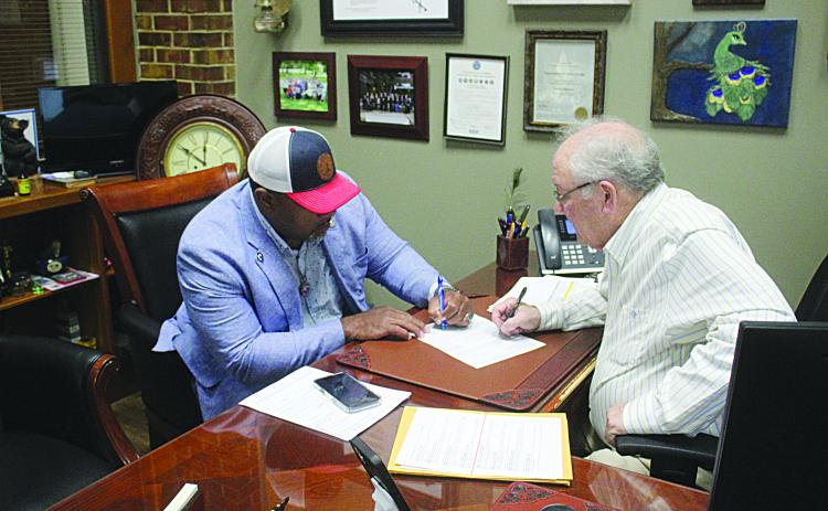 Ville Platte Mayor Ryan LeDay Williams (left) was the first candidate to qualify for the November 3, election. He is pictured as he signs the paperwork with Evangeline Parish Clerk of Court Randy Deshotel (right). Qualifying continues until Friday, August 7, at 4:30 p.m. (Gazette photo by Tony Marks)