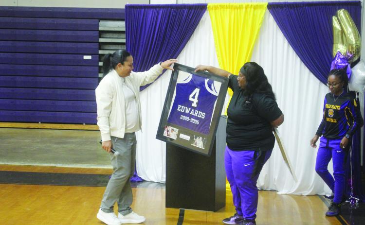 Ville Platte Lady Bulldog head coach Rhonda Thomas (right) presents a framed jersey to her former high school teammate Renotta Edwards (left). Edwards’ jersey is now retired and is on display in the school’s trophy case. (Gazette photo by Tony Marks)