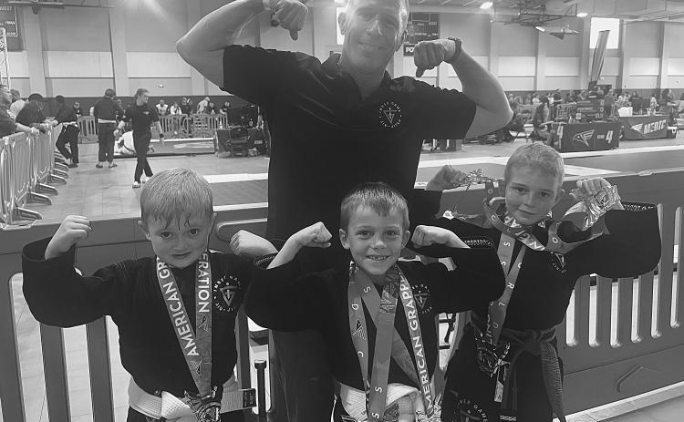 STUDENTS DO WELL IN TOURNAMENT - Standing in front, from left, Inner Game Jiu-Jitsu students Ian Mire, Weston Fontenot and Charlie Stevens excelled in a recent tournament held in New Orleans. They are shown with their proud coach Robbie Stevens, standing in back. (Photo courtesy of Robbie Stevens)