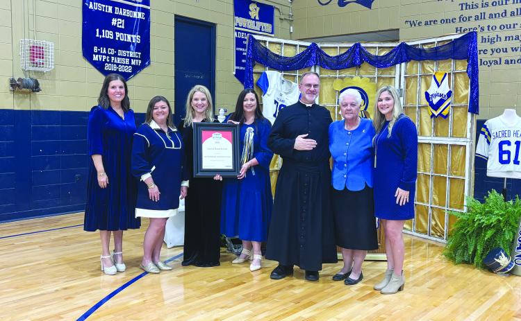 PRESTIGIOUS AWARD PRESENTED - During homecoming festivities on Friday, November 7, Sacred Heart School received the Cognia School of Distinction honor. Shown, from left, are Kylie LaHaye, high school curriculum coordinator; Jodi Andrus, elementary curriculum coordinator; Dawn Shipp, high school principal; Danielle Ardoin, elementary principal; Father Mitchell Guidry, pastor; Anna Larriviere, Superintendent of the Diocese of Lafayette Catholic Schools; and Sadie Fontenot, high school guidance counselor.