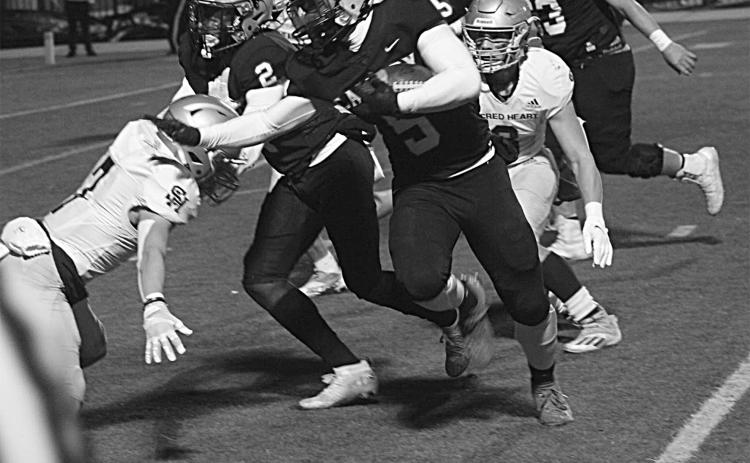 The Sacred Heart defense combines for a stop against Calvary Baptist in the Trojans’ quarterfinal loss, 63-7, in Shreveport Friday night. (Gazette photo by Rhett Manuel)