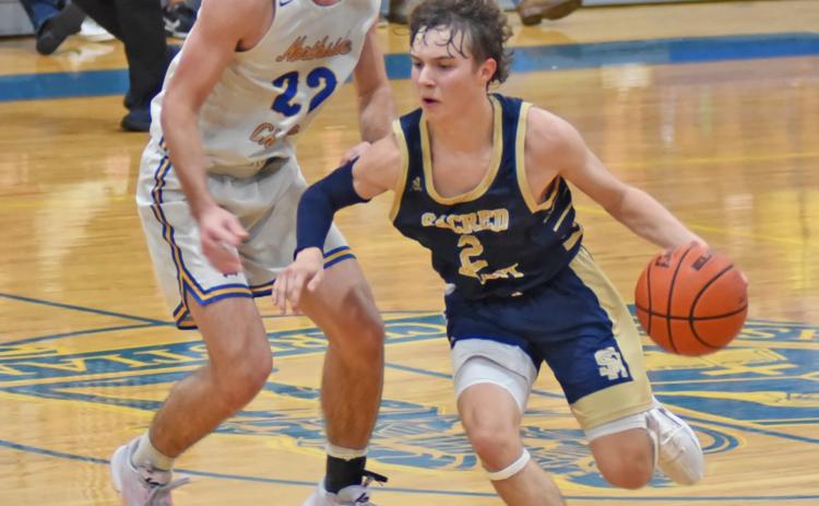 Sacred Heart’s Gabe Fontenot (2) dribbles the ball down the court in the Trojans’ season opening win against Northside Christian in Crowley. Fontenot scored 17 points on the night. (LSN photo by Chris Quebedeaux)