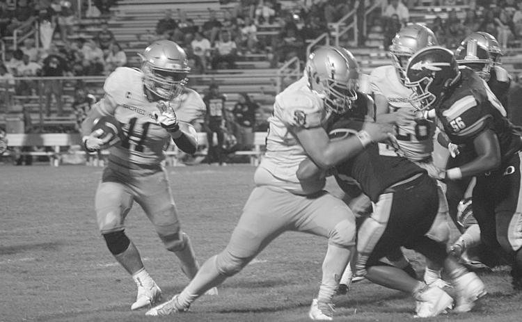 Ashton Duos (11) looks to turn a corner and pick up positive yardage in Sacred Heart’s regular season opening win against Oakdale, 32-0. (Gazette photo by Tony Marks)