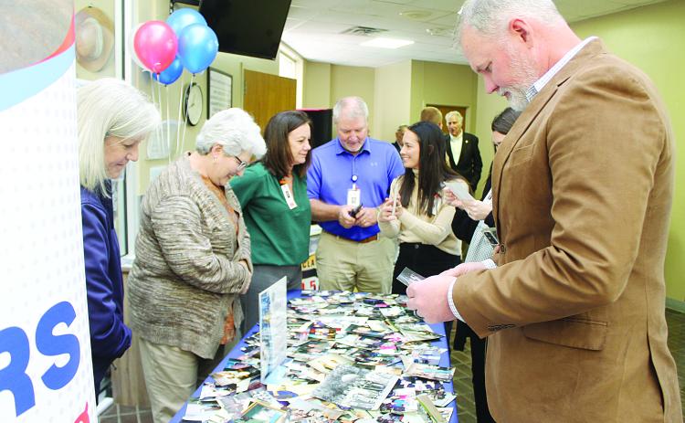 Staff members of Savoy Medical Center look through photographs depicting the hospital’s 75-year history during a celebration held Tuesday, December 16. Among those pictured are Chief Nursing Officer Laurie Manuel, Director of Hospital Operations Danny LaHaye, and Chief Executive Officer Brian Denton. (Gazette photo by Kathy Longino)