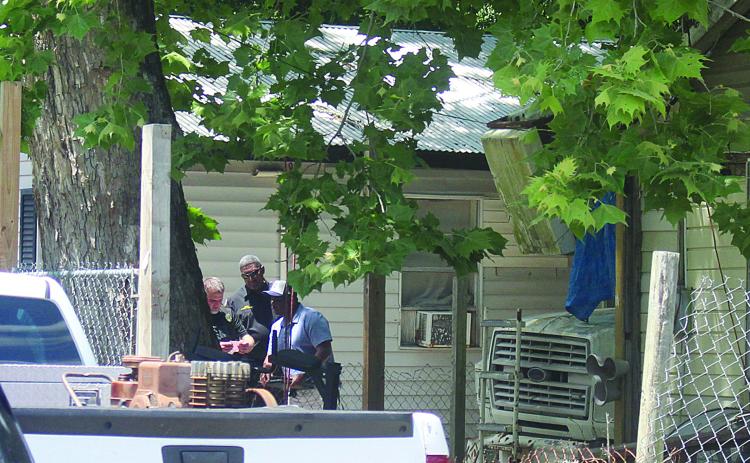 Ville Platte Chief of Police A. Perry Thomas (center) and other law enforcement officers investigate evidence collected at the scene of a fatal shooting in Ville Platte on Monday, May 4. (Gazette photo by Tony Marks)