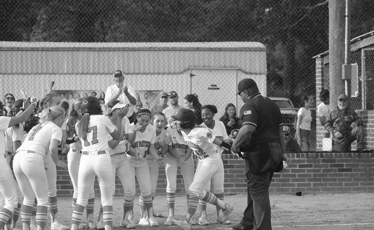 Josie Vidrine (12) celebrates at home plate with her Pine Prairie teammates after delivering a game-tying home run against South Beauregard on Monday. (Gazette photo by Tony Marks)