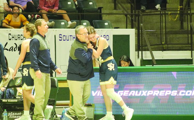 Sacred Heart girls’ basketball head coach Craig Whittington (left) consoles senior player Kali Shiver (right) as she exits the state semifinal game against Southern Lab. (Gazette photo by Tony Marks)