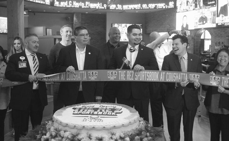 Flanked by members of the Coushatta Tribal Council Crystal Williams, Kristian Poncho, Loretta Williams, and Kevin Sickey, Chairman Jonathan Cernek (center) cuts the ribbon at the grand opening of The Rez Sportsbook in Kinder. Pictured from left in the back are former NFL players Owen Daniels, Rickey Jackson, and Drew Pearson. (Gazette photo by Tony Marks)