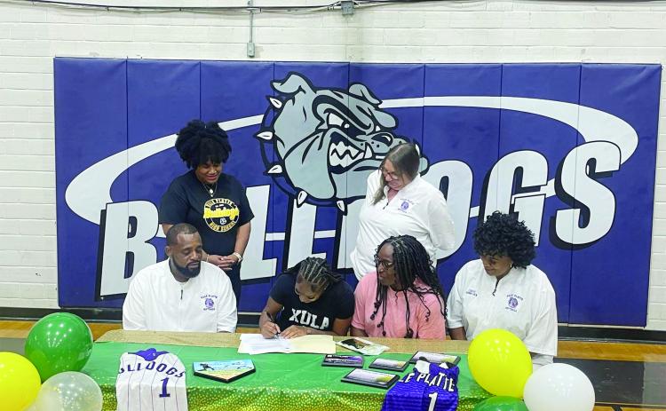 Destiny Lavigne (seated center left) is pictured as she signs to play college softball with Xavier University of Louisiana. Also pictured (from left) are standing Ville Platte High School Principal Shelsy Williams and former Ville Platte High School Assistant Principal Dawn Bellard; seated- Ville Platte High School Softball Coach Devinskie Arvie, Latoya Lavigne, and Ville Platte High School Assistant Coach Shonda Jack. (File photo)