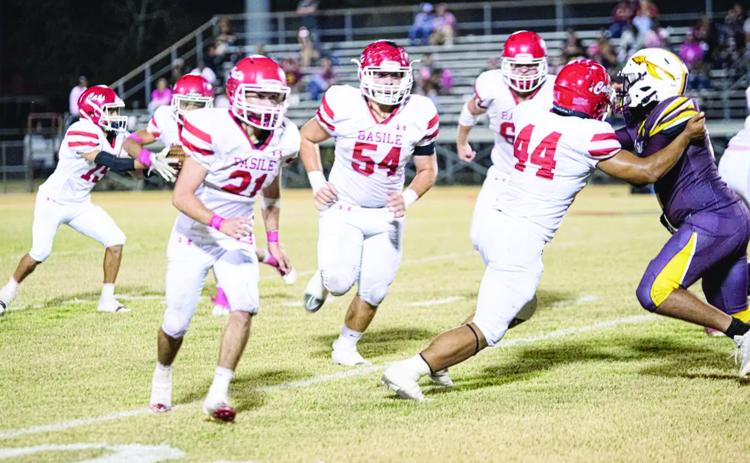 Pierre Berzas (54), Scott Berzas (60), and Da’Shawn Randall (44) pave the way for the Basile offense against an Elton defender.