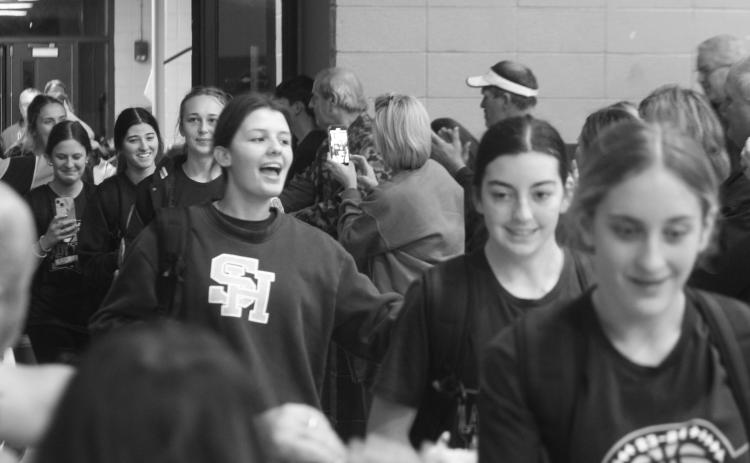 The Sacred Heart Lady Trojans are treated to a hero’s welcome as they return to the Halls of Troy after winning the District 6-1A championship on Tuesday night. (Gazette photo by Rhett Manuel)