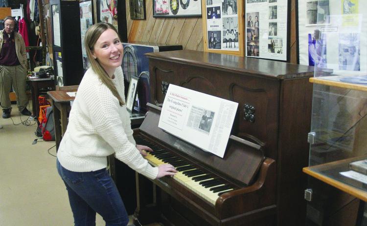 Marketing manager of Evangeline Parish Tourist Commission, Elizabeth West, tickles the ivories on the original piano from the Evangeline Club. (Gazette photo by Tony Marks)